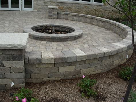 From retaining wall units, to pavers and outdoor living element designs; Stone patio with fire pit... I think I'd like it better ...
