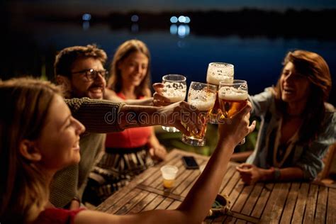 Group Of Friends Having A Toast Wit The Beer In The Bar On The Lake