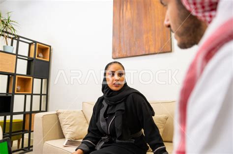 رجل اعمال سعودي و سيدة اعمال سعودية مجتمعان سويا داخل مقر الشركة ، ادارة الاعمال و المهام في