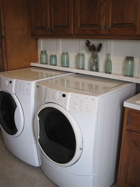 A stacked washer and dryer are hidden behind blue lattice doors located under stacked blue upper cabinets in a beautiful blue laundry room. Laundry Room {shelf behind washer and dryer | Shelves ...