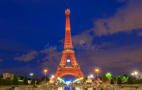 The Eiffel Tower Lit Up In Orange Color At Night Paris France