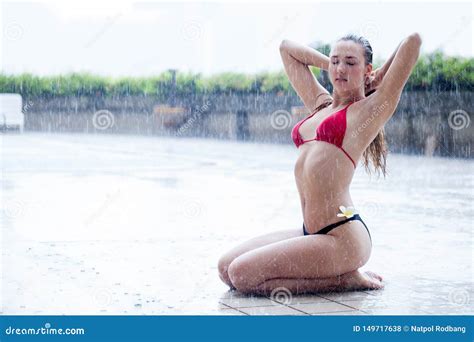 Beautiful Young Woman In Bikini Sitting And Posing By Swimming Pool