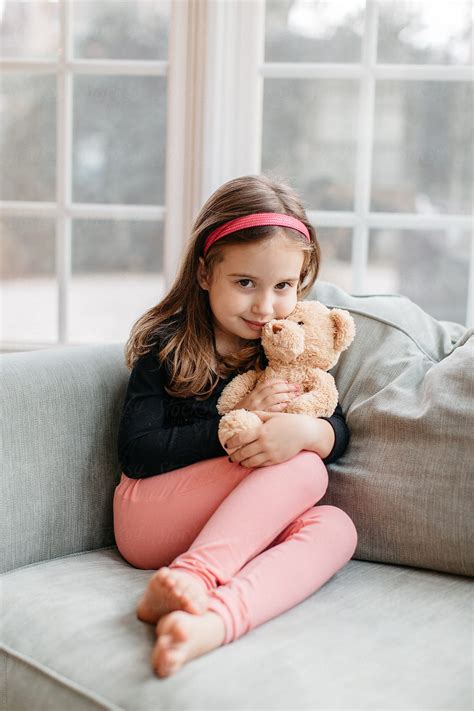 Beautiful Young Girl Sitting On A Big Chair With Her Teddy Bear By