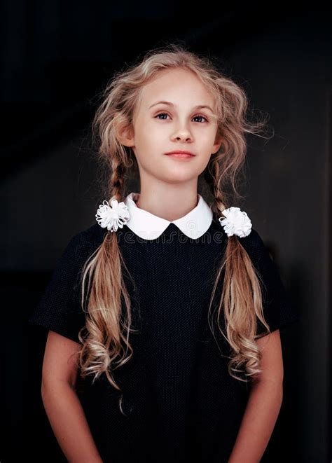 Portrait Of A Smiling Blonde Seven Year Old Girl In School Uniform