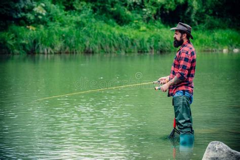 Fisherman Caught A Fish Man Angler Fishing On River Stock Photo