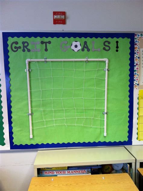 A Classroom With Two Desks And A Soccer Goal On The Bulletin Board Above It