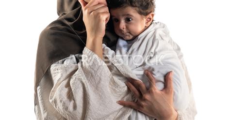بورتريه لأم عربية خليجية سعودية تحمل طفلها الرضيع بحب وحنان، تنظر الأم لأعلى بإيماءات تدل على