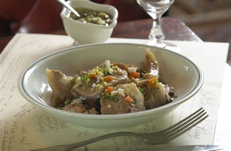 1/2 tête de veau (parée) 2 oignons 4 clous de girofle 2 feuilles de laurier 75 cl de lait 140 g de farine 30 g de beurre 25 cl de vin blanc 1 cuillerée à soupe de moutarde 1 pincée de sucre 50 g de câpres 50 g de cornichons 6 œufs durs 6 fleurons de pâte feuilletée sel, poivre du moulin. Recette de Tête de veau sauce ravigote