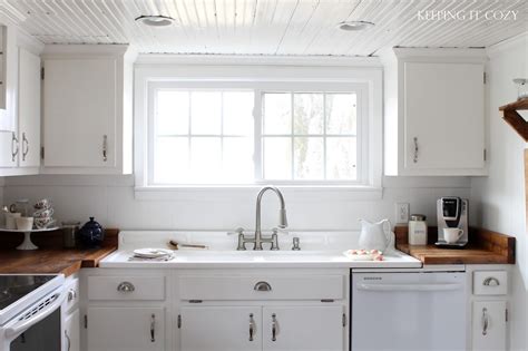 White beadboard cabinets are the easiest to use and style because the white finish enables it to be more versatile easily matching with both contemporary and classic black beadboard panels cover the cabinets and refrigerator. Keeping It Cozy: Our Farmhouse Kitchen