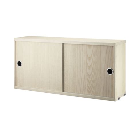 Manual sliding door systems create a feeling of openness and utilize space efficiently. Ash cabinet with sliding doors - String system