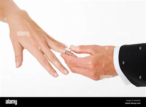 Groom Placing Ring On Brides Finger Stock Photo Alamy