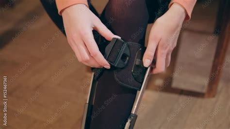 Detail Of The Lower Half Of A Lady Putting On A Supportive Leg Brace