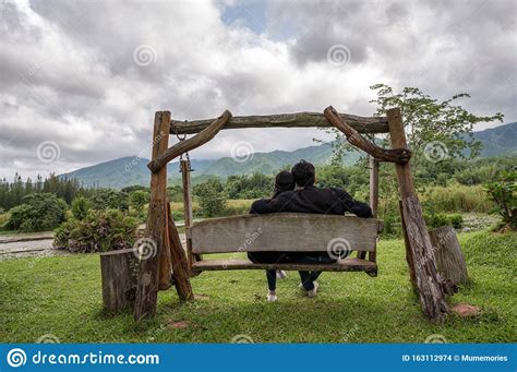 Young Couple Sitting On Wood Swing In National Park Editorial Stock