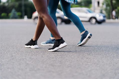 Two Multiethnic Girls Legs Jogging Through The City Streets Outdoor