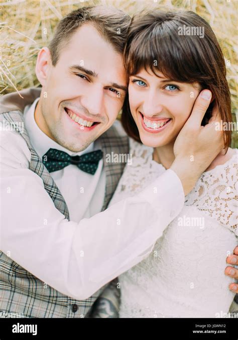 The Hugging Smiling Newlyweds Are Lying On The Hay The Close Up