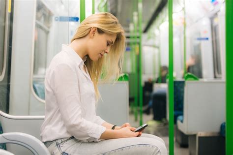 Mujer Joven Escribiendo En Un Teléfono Inteligente En El Tren Del Metro De Londres Foto Premium
