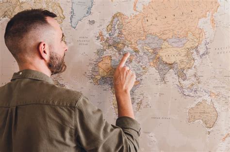 Rear View Of Man Pointing Vintage Map With His Finger Stock Image