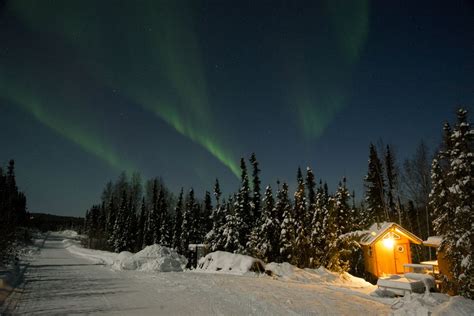 The Aurora Borealis Dances Over A Dry Cabin In Fairbanks Alaska