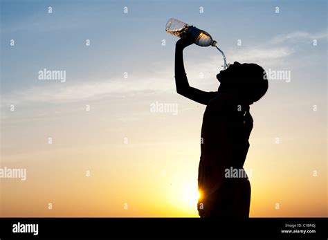 Indian Girl Drinking Mineral Water From Plastic Water Bottle At Sunset