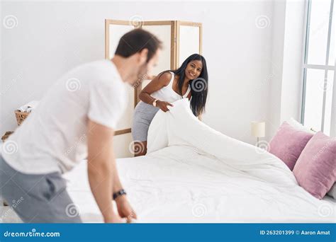 Man And Woman Interracial Couple Making Bed At Bedroom Stock Image