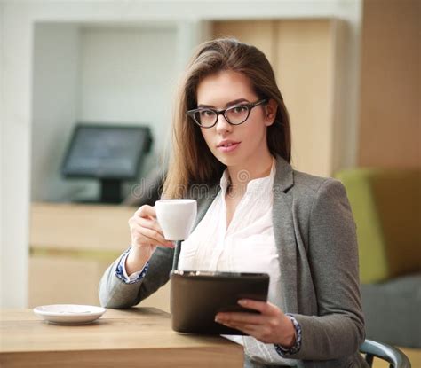 Young Business Woman With A Cup Of Coffee Working In Office Stock Photo