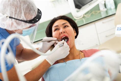 Male Dentist With Female Patient During Oral Checkup In Dentistry