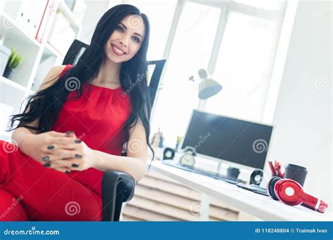 la belle jeune fille dans un costume rouge s assied dans une chaise dans le bureau photo stock