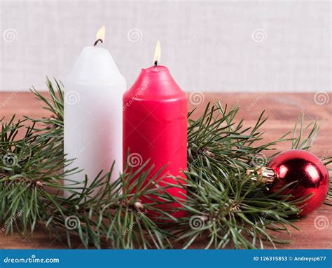 Two Candles Pine Branch And Christmas Ball On Christmas Background