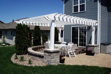 White Vinyl Pergola Over Brick Patio With Concrete Columns And Seat