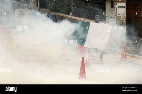 A Kashmiri Protester Holds A Pakistani National Flag Amid Tear Gas