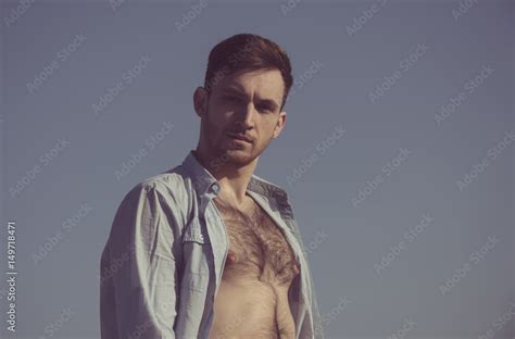Sexy Man Posing In Unbutton Shirt With Hairy Naked Chest Stock Photo