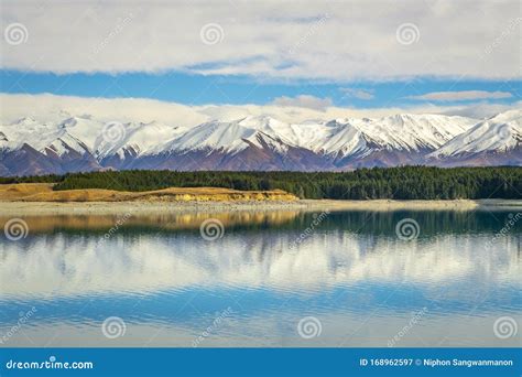 Panoramic View Of The Mountains And Lakeside Pine Trees Reflecting The
