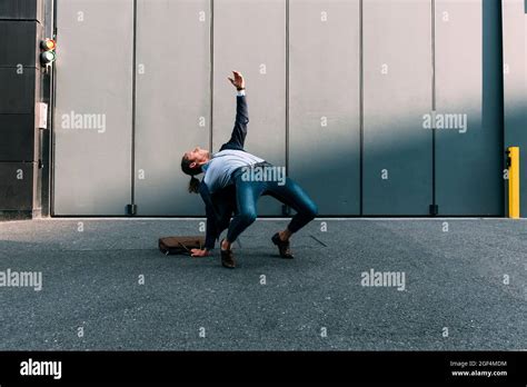 Businessman Bending Over Backwards On Footpath Stock Photo Alamy