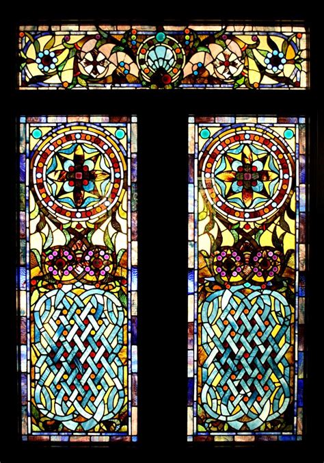 Two Stained Glass Windows With Designs On Them