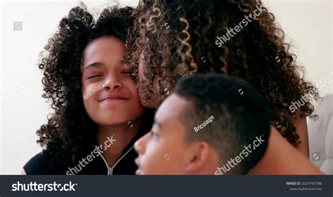 African Mother Kissing Embracing Daughter Candid Stock Photo