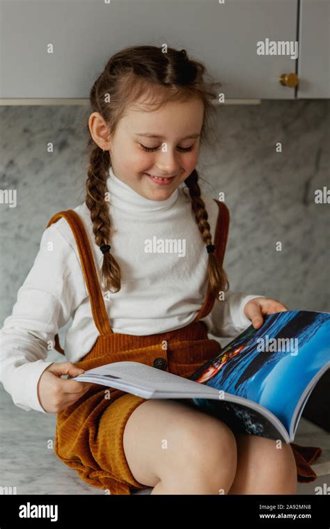 Smiling Girl Reading Book Stock Photo Alamy