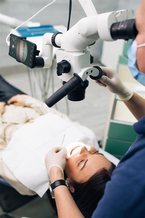 Close Up Of A Dentist Using Microscope Modern Equipment Microscope In