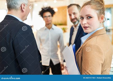 Young Businesswoman Making Small Talk With Colleagues Stock Photo
