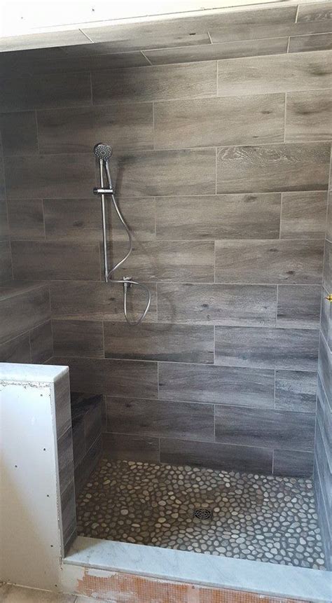 Because of the requirements of the shower floor, mosaics four inches or smaller is best on the floor. COOL wood grain porcelain shower and river rocks! (Stephen ...