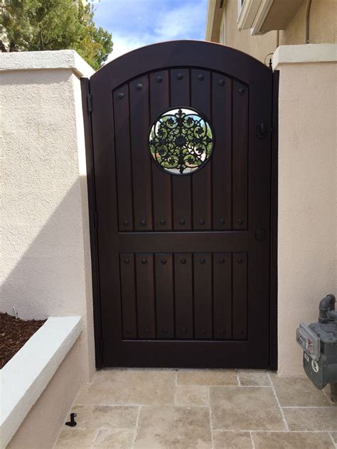 Custom Tuscan Style Wood Gate With Arched Top Circular Metal Grill And