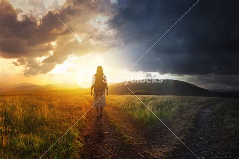 A Woman Walks Down A Path Towards Light Royalty Free Stock Image