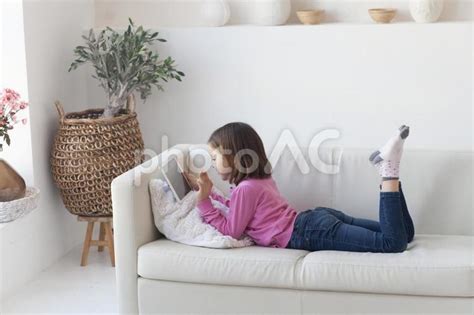 ソファで寝転ぶ女の子 No 4788737写真素材なら写真AC無料フリーダウンロードOK
