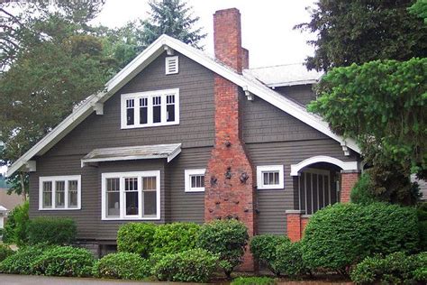 An elegant exterior with arches, high ceiling, strong pillars, slanting roof with roof tiles and curvy stairs leading to the home and the house washed in yellow light; Craftsman Bungalow - Redmond | Craftsman bungalows ...