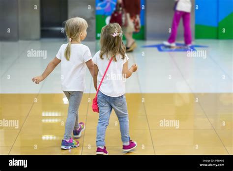 Two Cute Blond Little Girls Walking Together In Mall Pair Of Kid