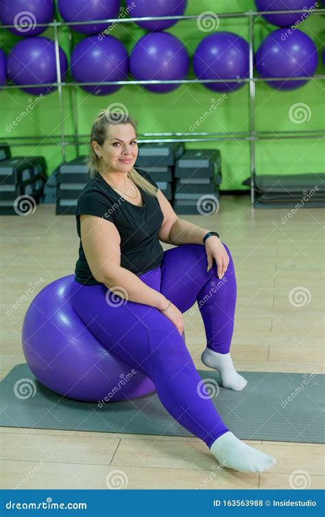 a fat woman is engaged in the gym and trying to lose weight an obese girl sits on a fitness