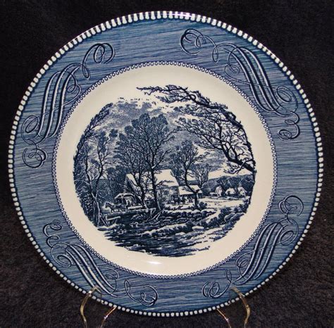 A Blue And White Plate Sitting On Top Of A Black Table Next To A Wall