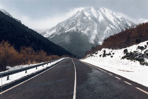 Winter Road With A Snowy Mountains In The Background By
