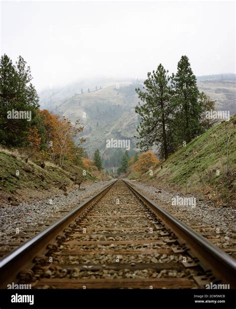 Train Tracks Disappear Into The Horizon Foggy Mountains Stock Photo Alamy