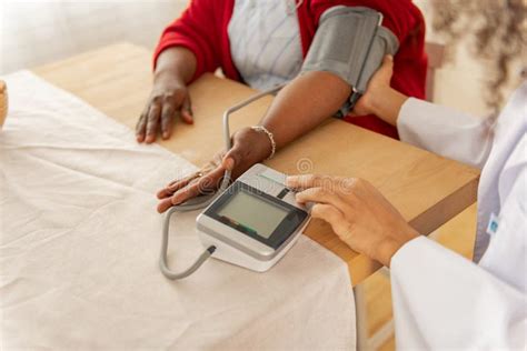 Close Up Of Professional Nurse Checking Blood Pressure For Woman Stock