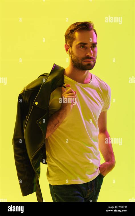Attractive Young Man Standing Isolated Over Yellow Background Holding